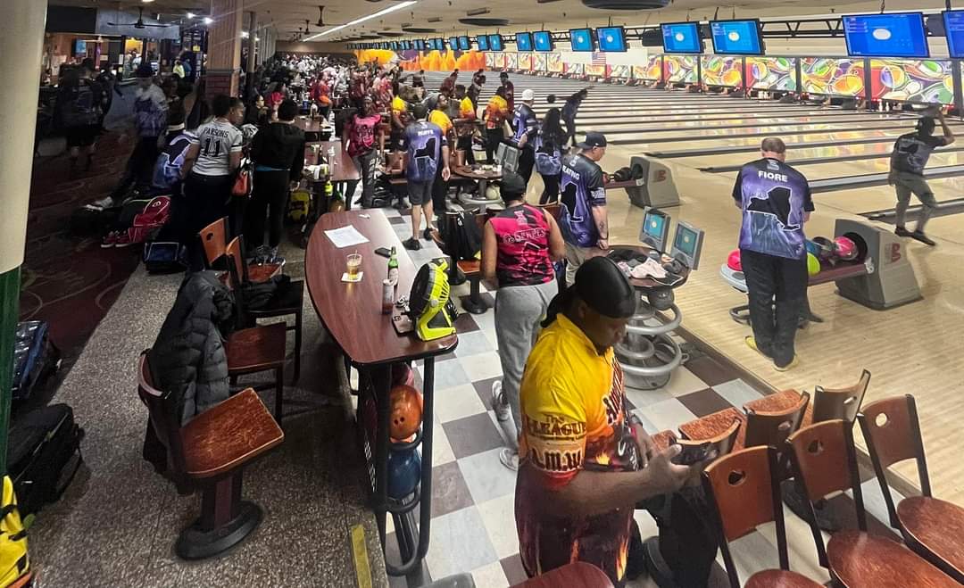 A bowling alley with a lot of people in it.